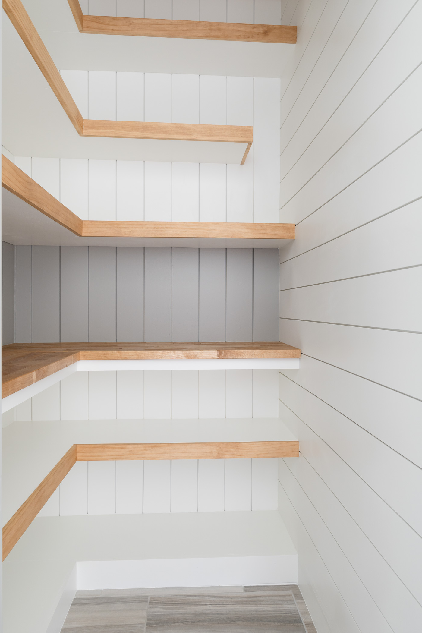 white shiplap walls with white and brown open shelving
